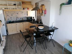 cocina con mesa y sillas en una habitación en casal do melro, en Ericeira