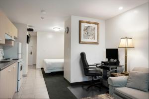 1 dormitorio y sala de estar con escritorio. en The Business Inn, en Ottawa