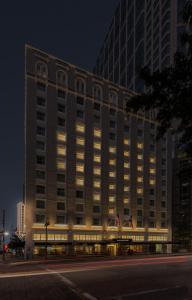 un gran edificio con luces delante de él por la noche en The Lancaster Hotel, en Houston