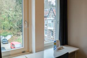 um quarto com uma janela com uma mesa branca e uma vista em Huis Ter Geul em Valkenburg