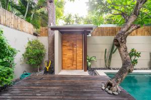 a house with a wooden door and a swimming pool at Villa Athena in Seminyak