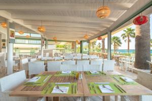 uma sala de jantar com mesa e cadeiras e o oceano em Star Beach Village & Water Park em Hersonissos