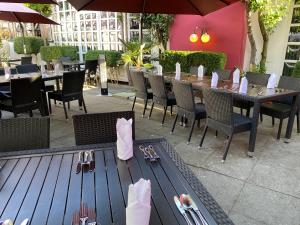 ein Restaurant mit einem Tisch, Stühlen und einem Tisch in der Unterkunft Eden-Hotel in Göttingen