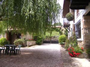 a courtyard with a table and chairs and a tree at Apartamentos Fernando in Santillana del Mar