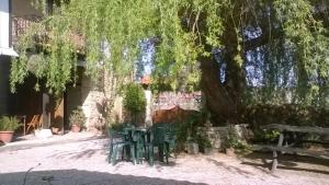 a table under a tree with two chairs under it at Apartamentos Fernando in Santillana del Mar