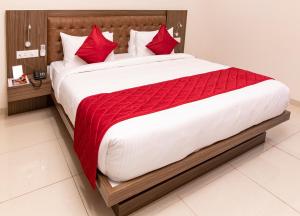 a bedroom with a large bed with red pillows at Aloka Stay Inn in Vellore