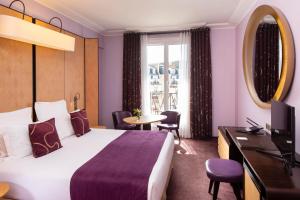 Cette chambre comprend un lit, un bureau et une télévision. dans l'établissement Hotel Maison FL, à Paris