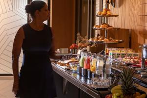 une femme debout devant un buffet dans l'établissement Hotel Maison FL, à Paris