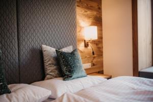 A bed or beds in a room at Gut Berg Naturhotel