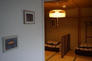 einen Flur mit einem Zimmer mit 2 Betten und einer Lampe in der Unterkunft Guesthouse Ten-roku - Female Only in Osaka