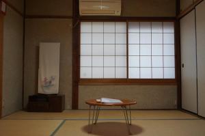 einen kleinen Tisch in einem Zimmer mit Fenster in der Unterkunft Guesthouse Ten-roku - Female Only in Osaka