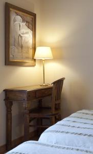 - un bureau avec une lampe à côté d'un lit dans l'établissement Hotel Don Carlos Cáceres, à Cáceres