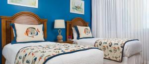 2 camas en un dormitorio con paredes azules en The Tuscany on Grace Bay, en Grace Bay