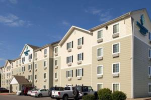 een groot gebouw met auto's geparkeerd op een parkeerplaats bij WoodSpring Suites Clarksville Ft. Campbell in Clarksville