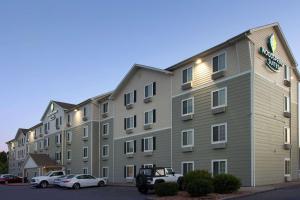 een groot gebouw met auto's geparkeerd voor het bij WoodSpring Suites Clarksville Ft. Campbell in Clarksville