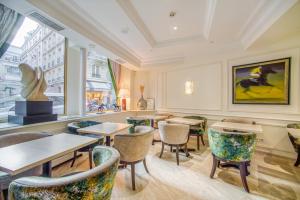 a restaurant with tables and chairs and a window at Queens Boutique Hotel in Paris