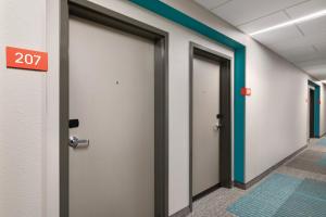 une rangée de portes dans un couloir avec le numéro dans l'établissement avid hotels - Boston Logan Airport - Revere, an IHG Hotel, à Revere