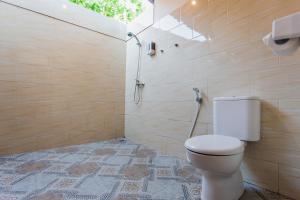 uma casa de banho com um WC e um chuveiro com uma janela em Camar Cottage & Hostel em Nusa Penida