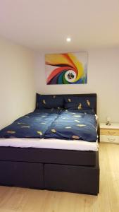 1 dormitorio con 1 cama con una pintura en la pared en Lilli Ferienwohnung, en Handewitt