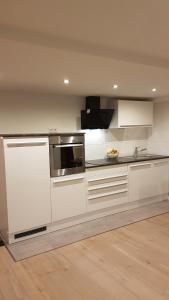 cocina con armarios blancos y encimera en Lilli Ferienwohnung, en Handewitt