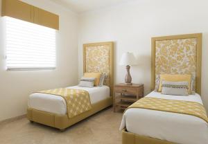 a bedroom with two beds and a table and a window at The Venetian on Grace Bay in Grace Bay