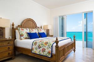 a bedroom with a bed with a view of the ocean at The Venetian on Grace Bay in Grace Bay