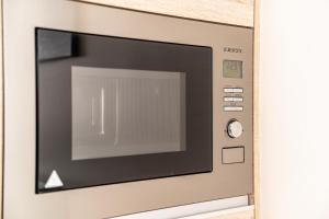 un horno microondas con la puerta abierta en una pared en Bracara Guest House "Campo das Hortas", en Braga