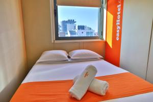 een bed met twee handdoeken en een raam bij easyHotel Sofia in Sofia