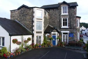 une grande maison en briques avec des fleurs devant elle dans l'établissement Sunnyside Guest House, à Keswick