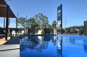 una piscina de agua azul frente a un edificio en Orana Motel, en Dubbo