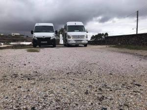 Due furgoni bianchi parcheggiati su una strada sterrata. di Antonia Hotel a Firà