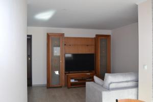 uma sala de estar com um sofá e uma televisão de ecrã plano em Rocha Apartment 1016 em Portimão