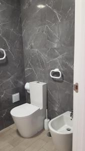 uma casa de banho com um WC branco e um lavatório. em Rocha Apartment 1016 em Portimão