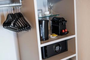 a kitchen cabinet with a microwave and utensils at Stay COOPER l Goethe Guesthouse in Bolzano