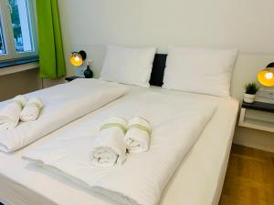 zwei weiße Betten mit Handtüchern darüber in der Unterkunft bestprice Hotel Aachen Hauptbahnhof in Aachen