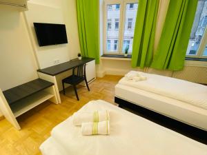 Zimmer mit 2 Betten und einem Schreibtisch mit einem TV in der Unterkunft bestprice Hotel Aachen Hauptbahnhof in Aachen