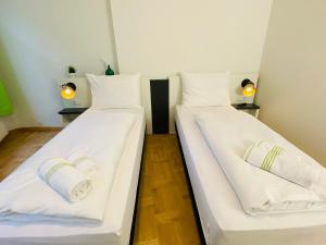 2 Betten in einem Zimmer mit weißer Bettwäsche in der Unterkunft bestprice Hotel Aachen Hauptbahnhof in Aachen