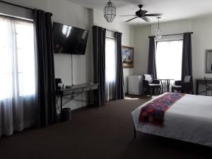 een slaapkamer met een bed en een flatscreen-tv bij Hotel La Casona 30 in San Miguel de Allende