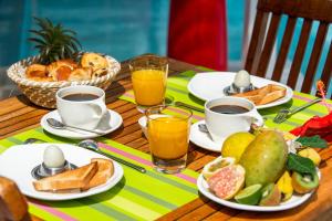 un tavolo ricoperto di piatti di cibo e tazze di caffè di Hôtel Frégate Bleue a Le François