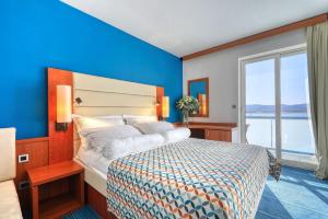 um quarto com uma cama com uma parede azul em Hotel Kornati em Biograd na Moru