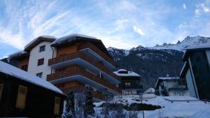 ein Gebäude im Schnee mit Bergen im Hintergrund in der Unterkunft Appartement in 1700m mit Traumblick in Grächen