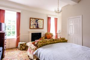 a bedroom with a bed and a couch and a fireplace at Mangreen Country House in Norwich