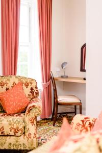 a living room with a couch and a chair and a window at Mangreen Country House in Norwich