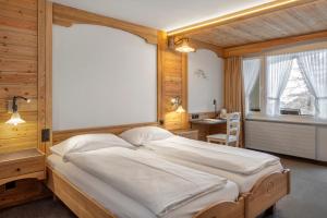 a bedroom with a large bed and a window at Hotel Antika in Zermatt