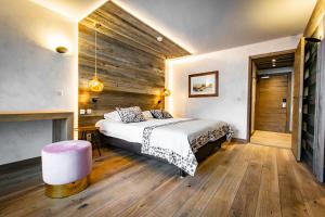 1 dormitorio con 1 cama y chimenea en Hôtel Champs Fleuris Morzine, en Morzine