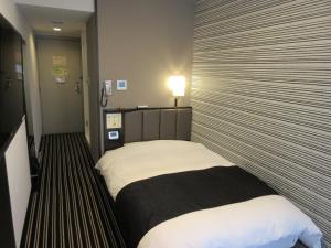 una camera d'albergo con un letto in una stanza di APA Hotel Utsunomiya-Ekimae a Utsunomiya