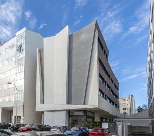 a large white building with cars parked in front of it at Hotel BESTPRICE Alcalá in Madrid