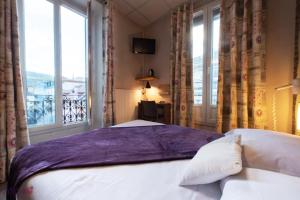 - une chambre avec un lit et une grande fenêtre dans l'établissement Atipik Hôtel, à Annecy