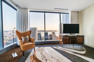 uma sala de estar com televisão e janelas grandes em Lotte Hotel Seattle em Seattle