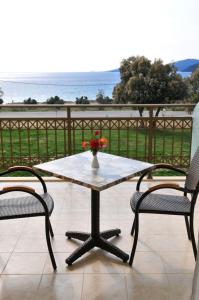 d'une table avec deux chaises et d'un vase avec des fleurs. dans l'établissement Finiki Plaza, à Methoni